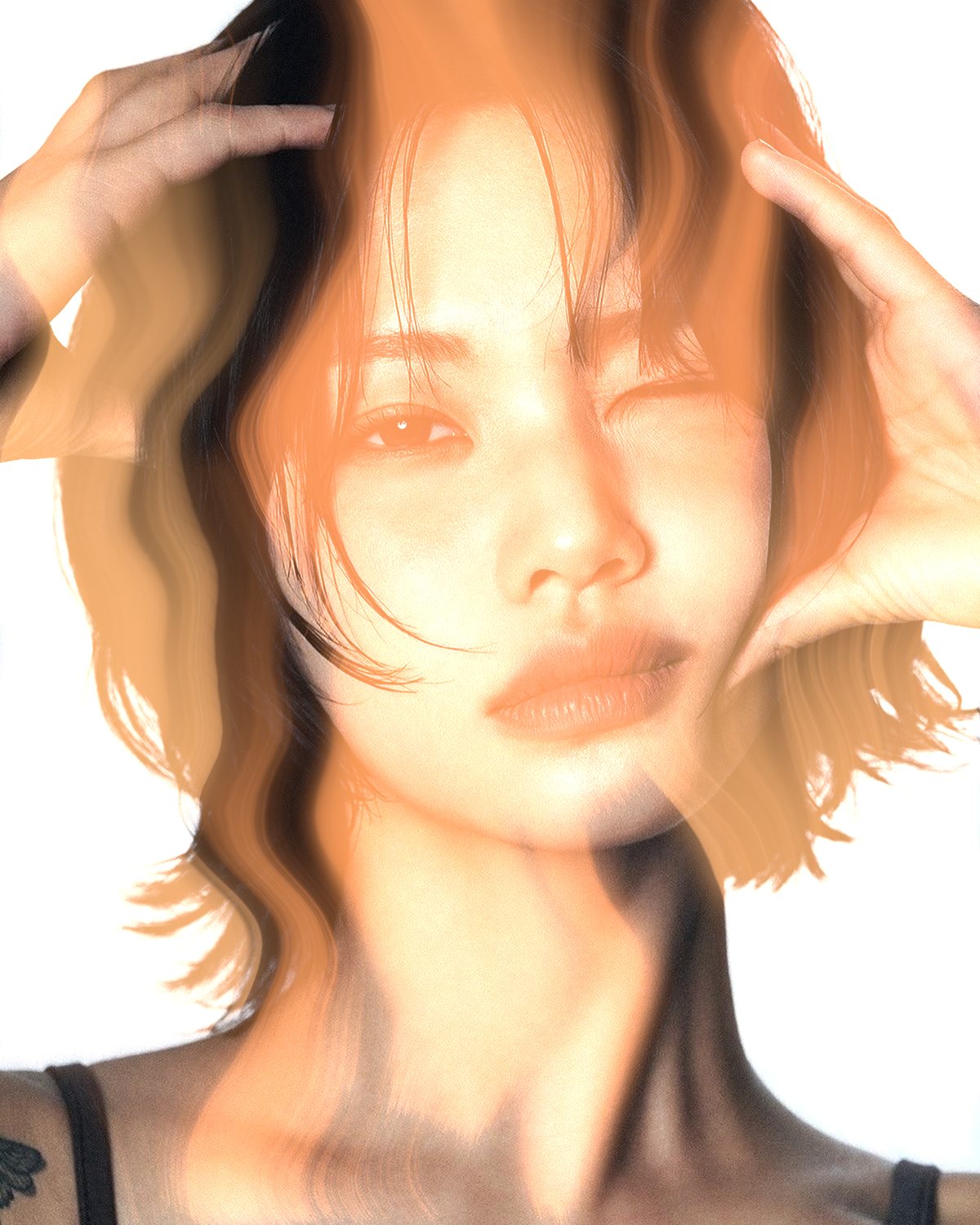 Smoke effect on a portrait of a woman with black hair, hands on her head, made with the Mist filter in Filter Archive (Ember preset)