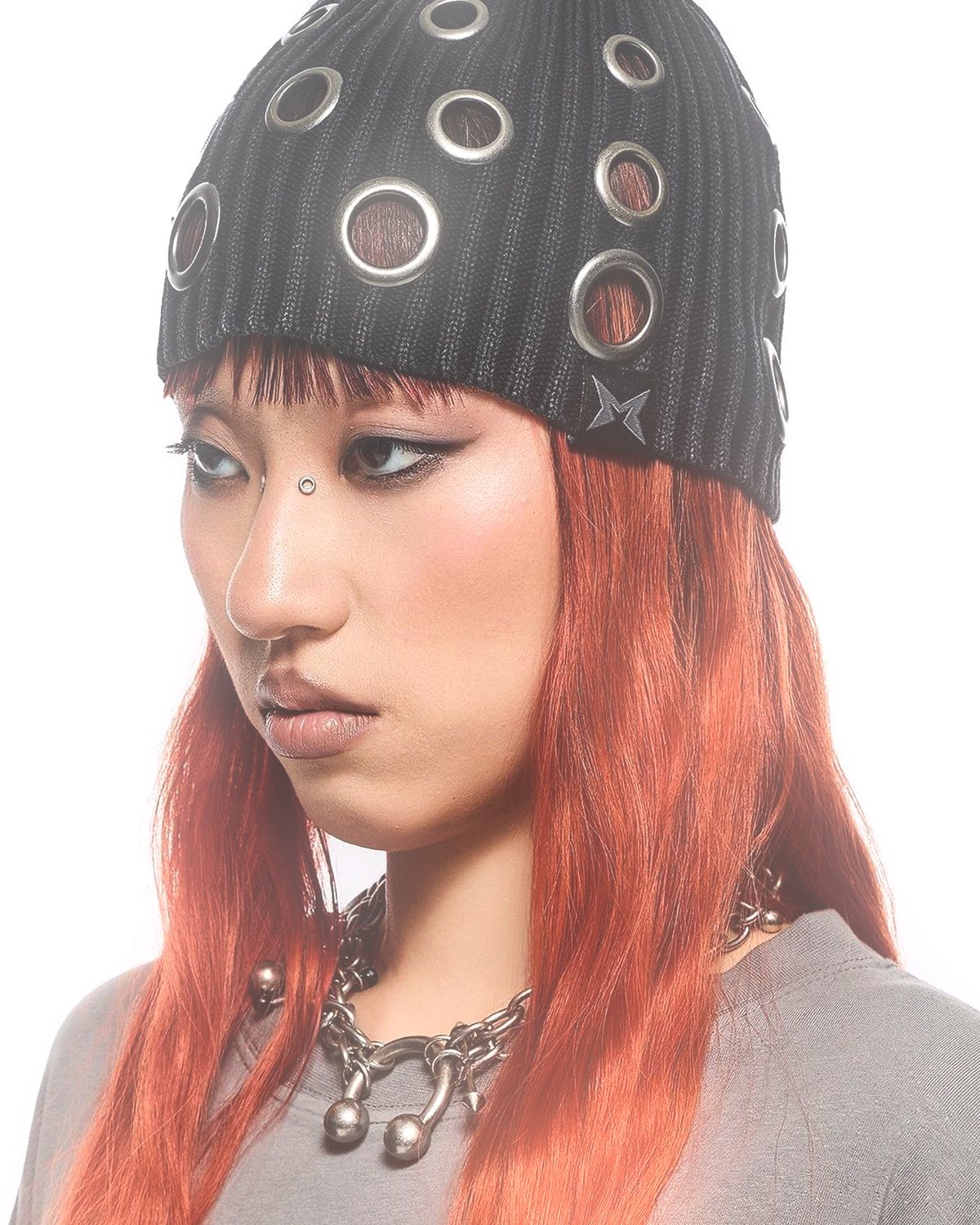 Soft glow effect on a portrait of a woman with red hair in a studded beanie, made with the Glow Up filter in Filter Archive (Subtle preset)
