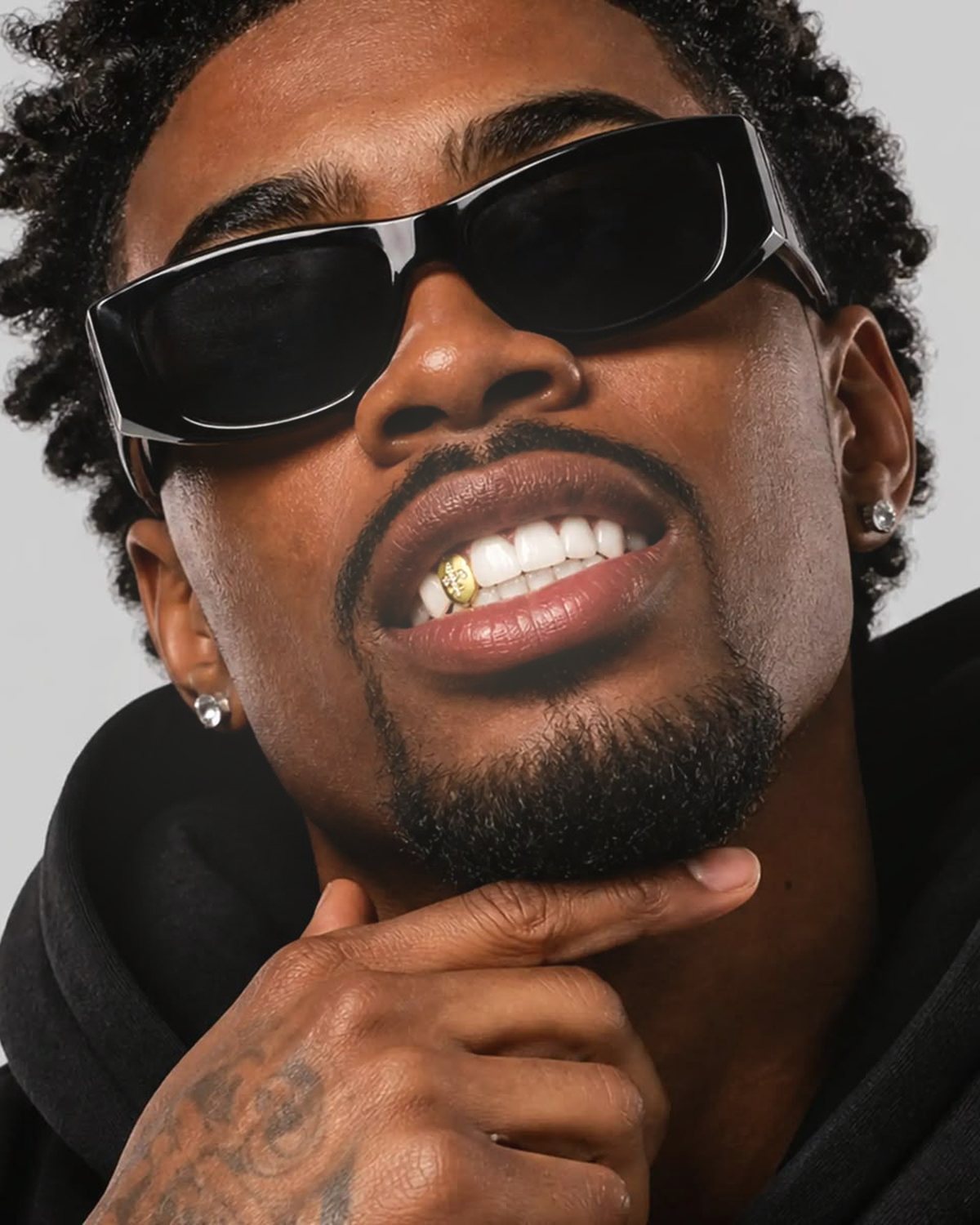 Soft glow effect on a portrait of a man in black sunglasses, made with the Glow Up filter in Filter Archive (Halo preset)