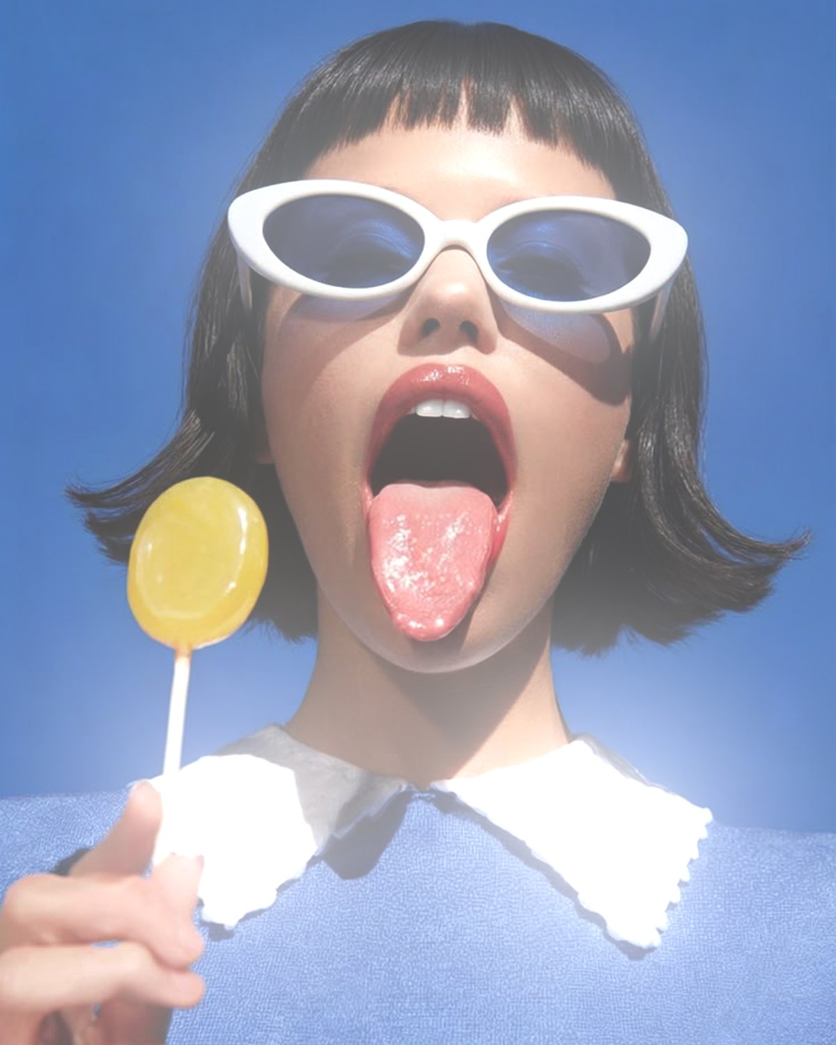 Soft glow effect on a portrait of a woman in white sunglasses with a lollipop, made with the Glow Up filter in Filter Archive (Halo preset)