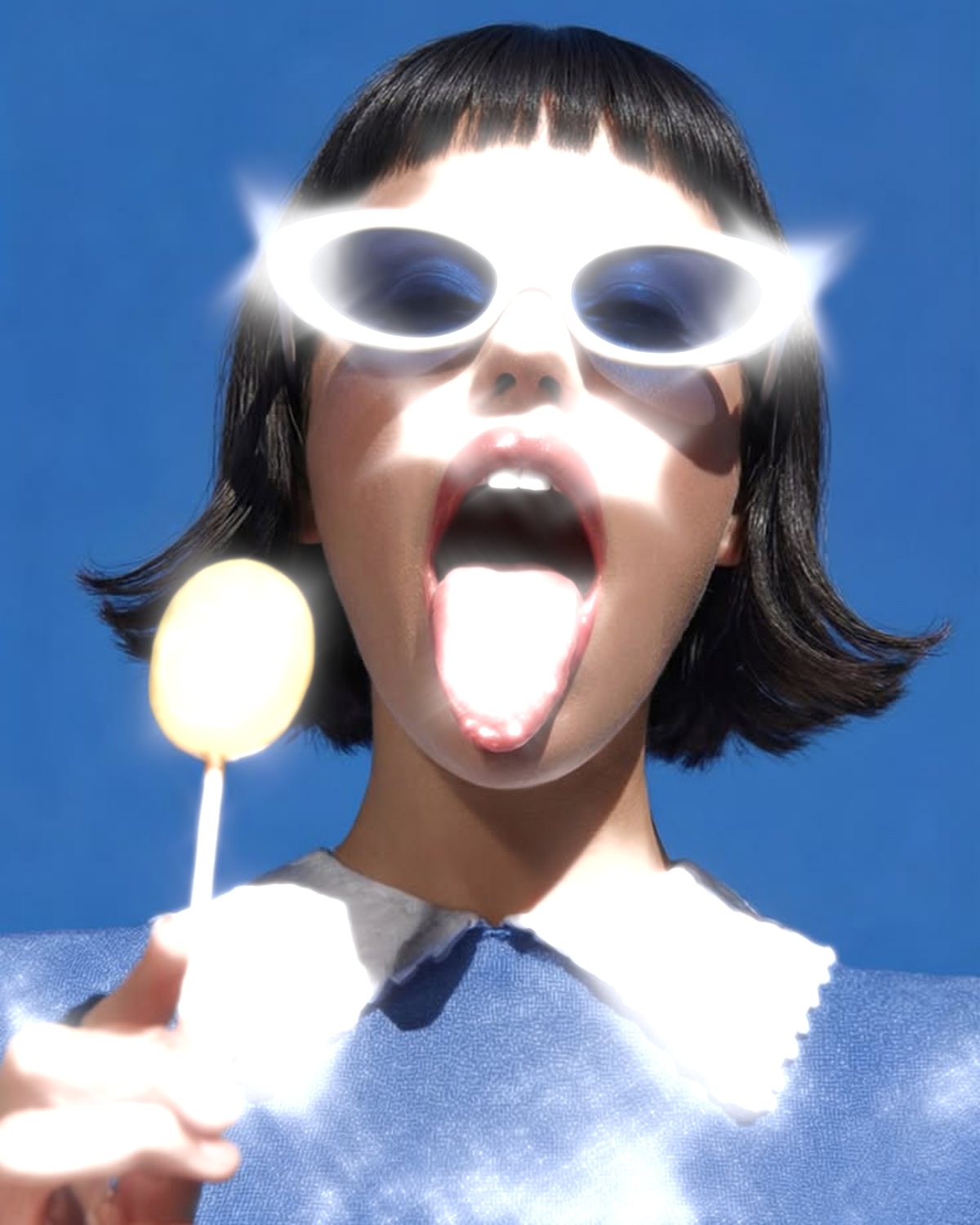 Star filter effect on a portrait of a woman in white sunglasses with a lollipop, made with the Starlight filter in Filter Archive (Starburst preset)
