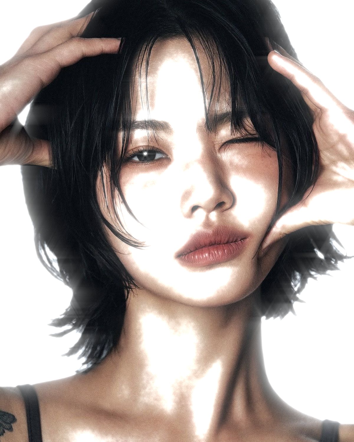 Star filter effect on a portrait of a woman with black hair, hands on her head, made with the Starlight filter in Filter Archive (Soft Bloom preset)